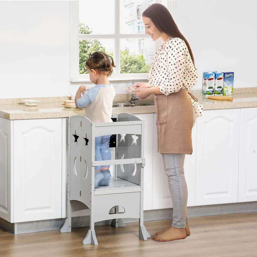 A toddler using a kitchen helper to assist a lady with preparing food in the kitchen